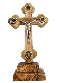 Wooden cross with a figure on top on a gray surface